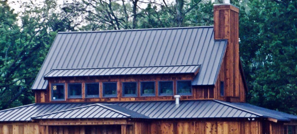 Metal roof on nice home in the woods to illustrate Metal Roof Architecture: Form + Function + Longevity