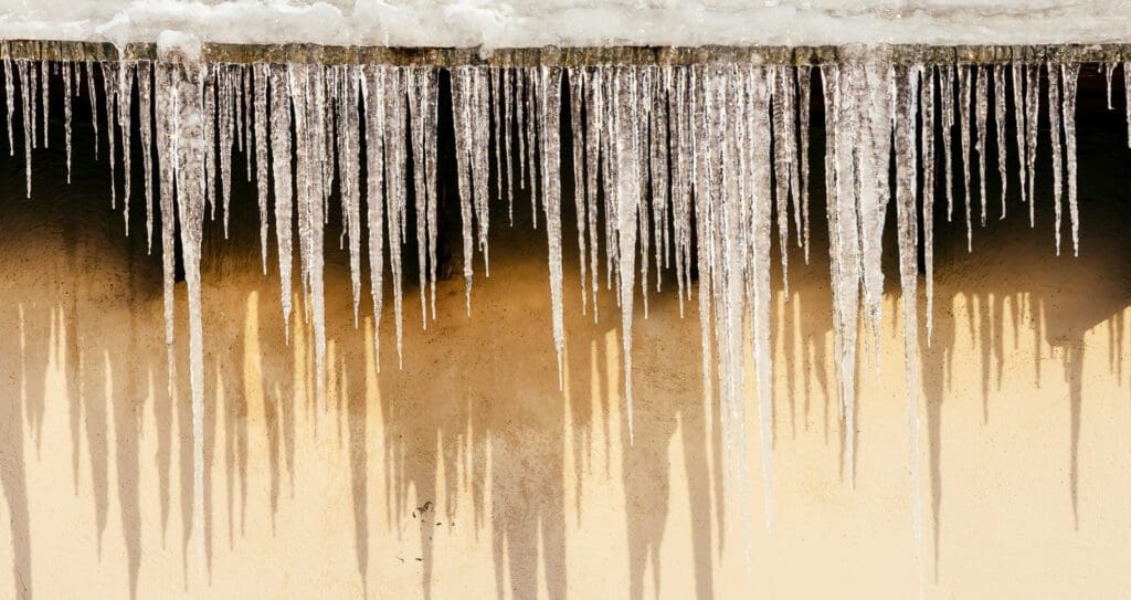 Icicles hanging from residential roof line.