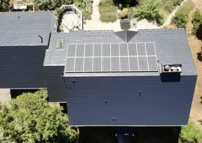 Aerial view of gray slat metal roof with solar panels