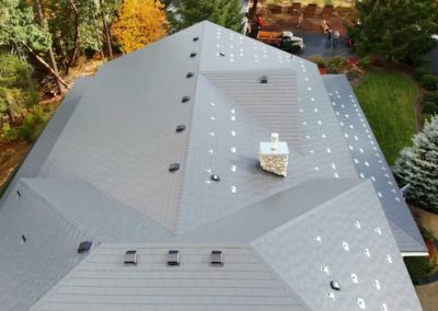 Gray composite shingle metal roof and roof vents