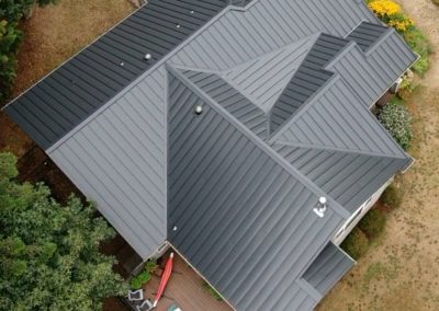 Ariel view of a black standing seam metal roof in La Center, WA to help illustrate How to Install Metal Roofing Over Shingles