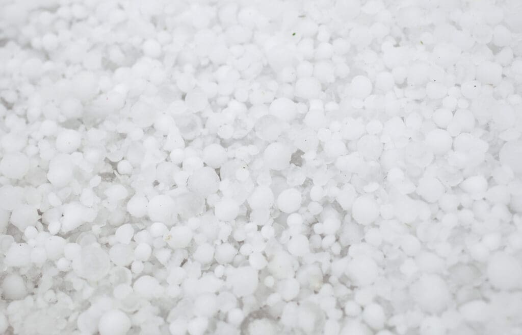 Settled hailstones after a sudden heavy storm to illustrate can hail damage a metal roof