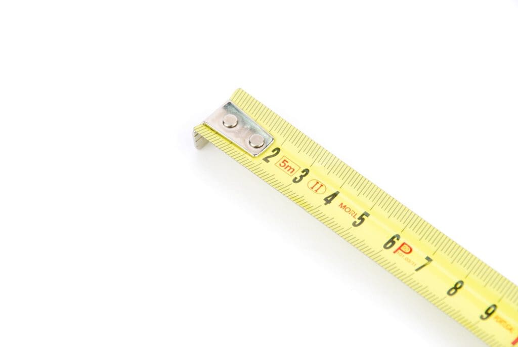 measuring tape on a white background to illustrate How Wide Is Metal Roofing