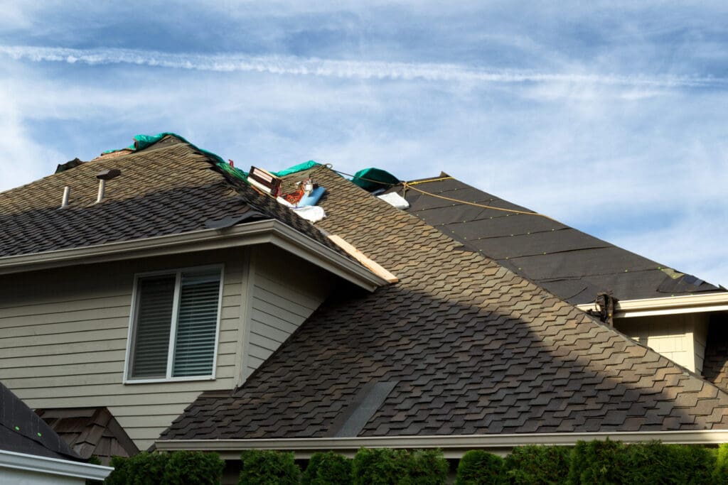 Home roof being replaced with new composite roofing materials to illustrate How Long Do Composite Roofs Last