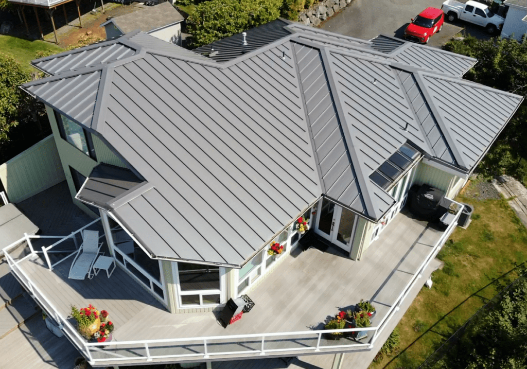 An image of a new, gray metal roof on a beautiful home from above to illustrate different metal roof types.